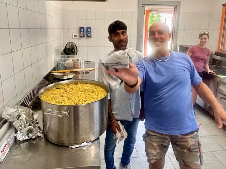 Il pentolone di riso è pronto: un volontario alza il pollice.