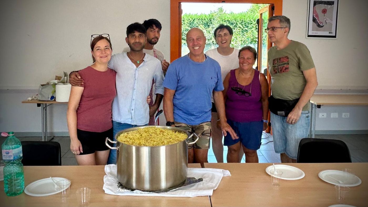 Il gruppo in posa dietro una grande pentola di riso appena cotto.